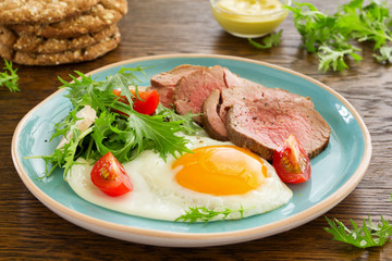 Scrambled eggs with roast beef and salad.