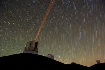 Telescope in Hawaii using a red laser guide star. - obrazy, fototapety, plakaty
