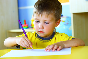 Smiling boy paints paints