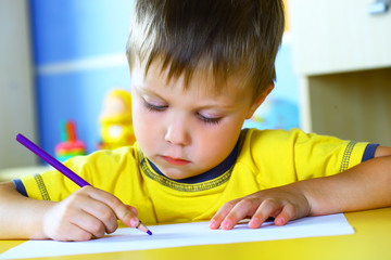 Smiling boy paints paints