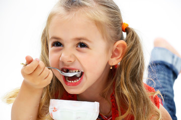 Little smiling girl eating ice cream