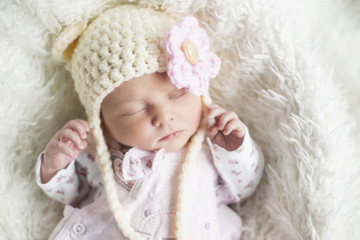 Fototapeta na wymiar Newborn Mädchen mit süßer Mütze Nahaufnahme