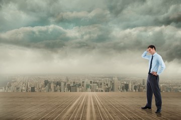 Composite image of thoughtful businessman with hand on head