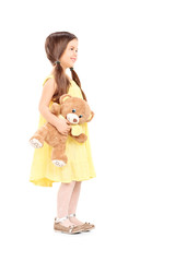 Full length portrait of cute child holding a teddy bear