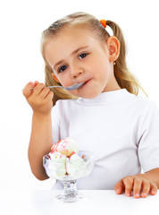 Little smiling girl eating ice cream