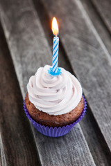 Tasty birthday cupcake with candle