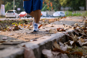 close up of feet of a runner running in autumn
