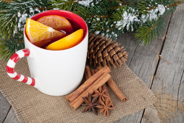 Obraz na płótnie Canvas Christmas mulled wine with spices and snowy fir tree