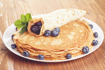 russian pancakes with blueberries on wooden table