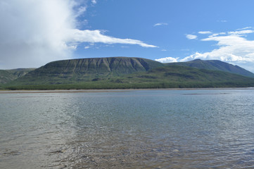 The sky in the clouds over the mountain river.