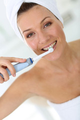 Woman brushing her teeth with electrical toothbrush