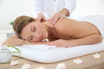 Woman in spa institute receiving oil massage - obrazy, fototapety, plakaty
