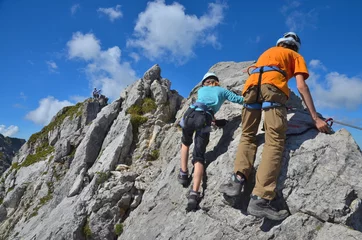 Crédence de cuisine en verre imprimé Alpinisme Les enfants grimpent sur le rocher dans la via ferrata