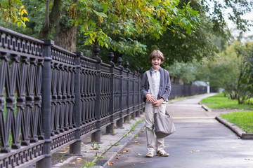 Fototapeta na wymiar School boy walking home on a rainy autumn day