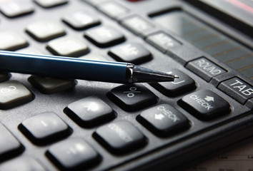 Closeup image of calculator keyboard and pen