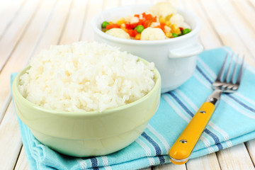 Cooked rice with vegetables on wooden table close up