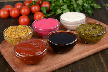 Various sauces on chopping board on table close-up