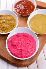 Various sauces on chopping board on table close-up