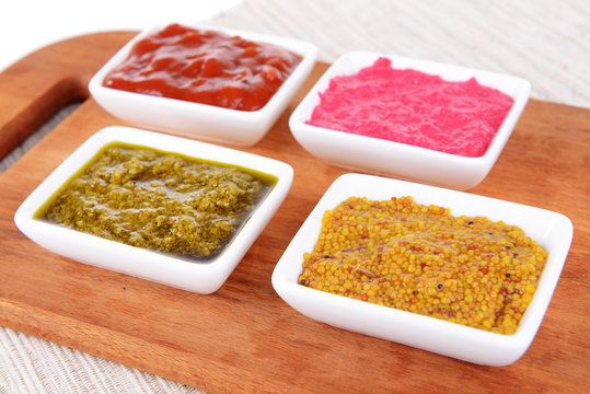 Various sauces on chopping board on table close-up
