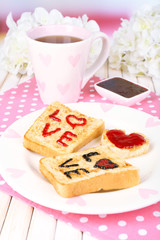 Delicious toast with jam and cup of tea on table close-up