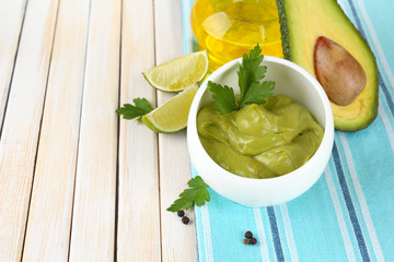 Fresh guacamole in bowl on wooden table
