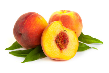 Three perfect, ripe peaches with a half  and slices isolated on