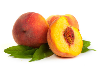 Three perfect, ripe peaches with a half  and slices isolated on