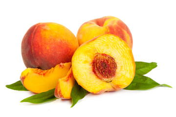 Three perfect, ripe peaches with a half  and slices isolated on