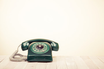 Retro green telephone on wooden table