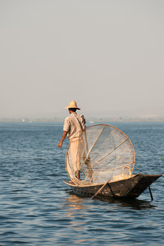 A Burmese fisherman on his boat at Inle Lake, Myanmar