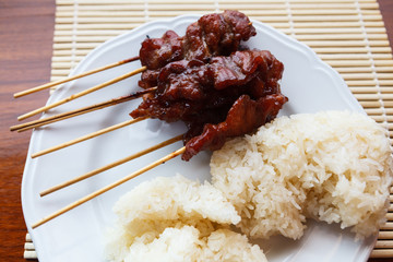 Thai street food style, roasted pork with white sticky rice in w
