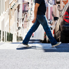 Mann mit Einkaufstüte überquert die Straße