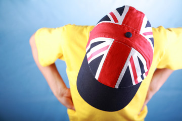 Boy in a yellow t-shirt wearing baseball cap with Union jack