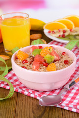 Delicious oatmeal with fruit in bowl on table close-up
