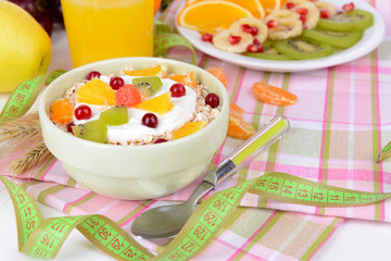 Delicious oatmeal with fruit in bowl on table close-up
