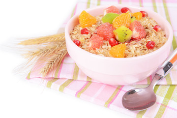 Delicious oatmeal with fruit in bowl on table close-up