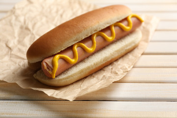 Tasty hot dog on wooden table