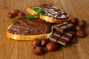 Bread with sweet chocolate hazelnut spread on wooden background