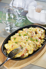 Assorted meat and vegetables with melted cheese on a table