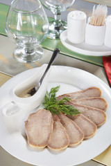 Chopped boiled beef tongue in a plate on the served table
