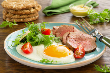 Scrambled eggs with roast beef and salad.