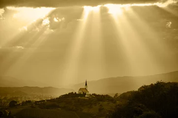 Deurstickers Zonnestralen die op een kerk schijnen © Dziurek