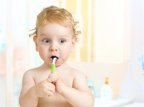 Kid Brushing Teeth In Bathroom