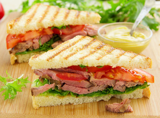 Panini closeup with roast beef and salad.