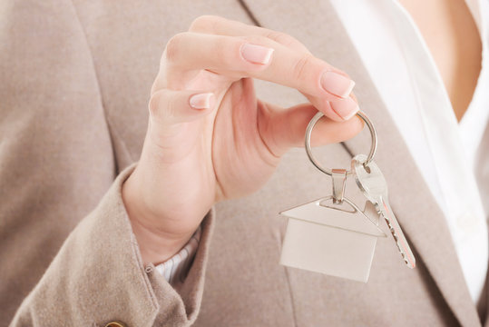 Caucasian business woman holds home keys.