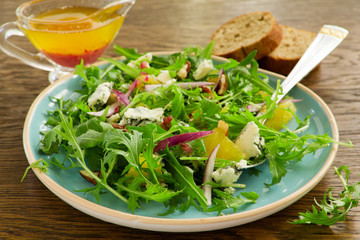 Salad with oranges, arugula, walnuts and blue cheese.