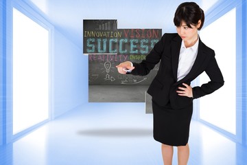 Fototapeta premium Composite image of focused businesswoman pointing