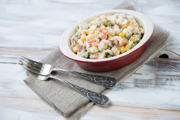 Olivier salad over wooden background