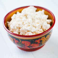 Fresh cottage cheese in wooden khokhloma tableware