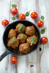Meatballs with tomato sauce in a frying pan, view from above